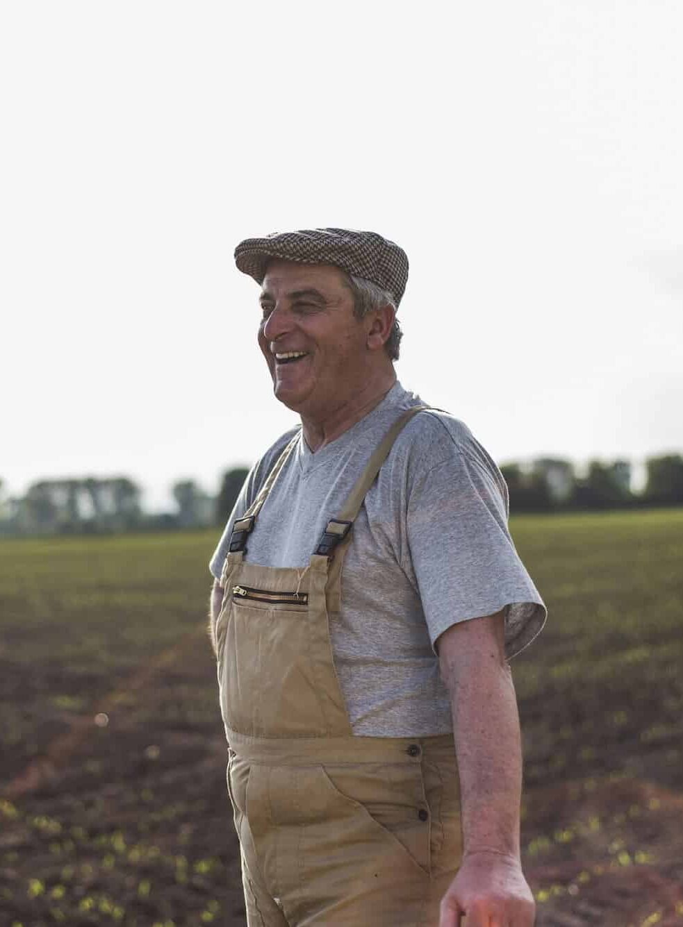 Smiling farmer standing at a field